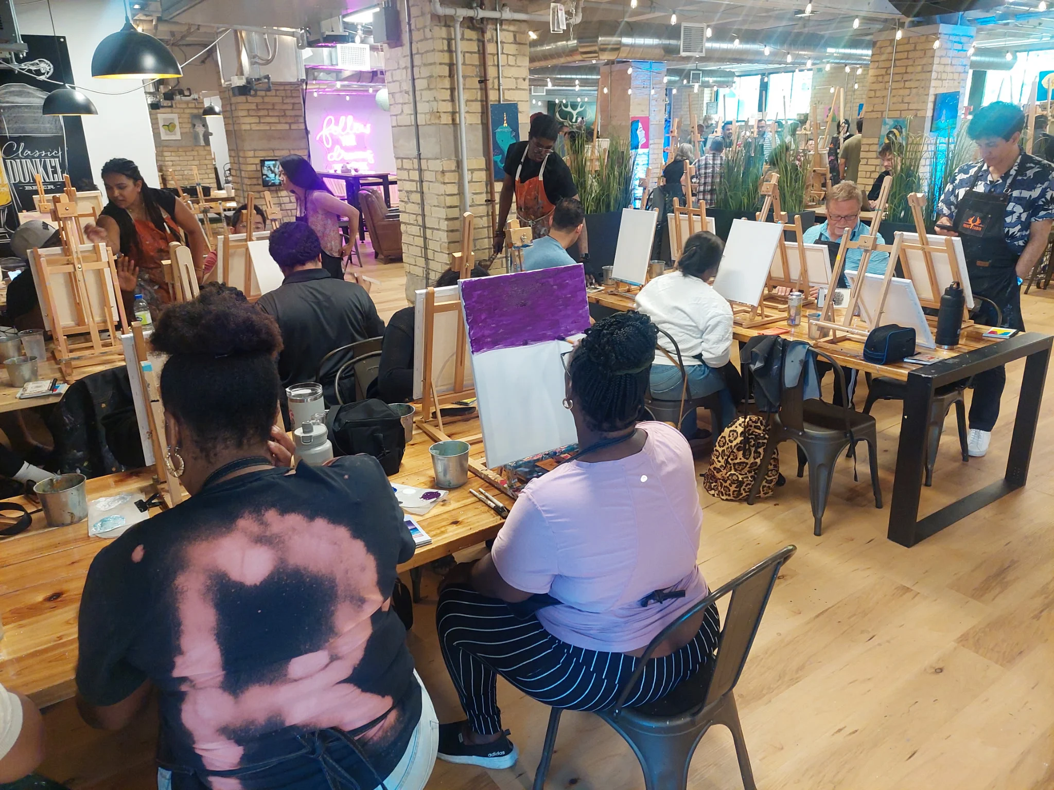 Participants paint at easels during a group painting session